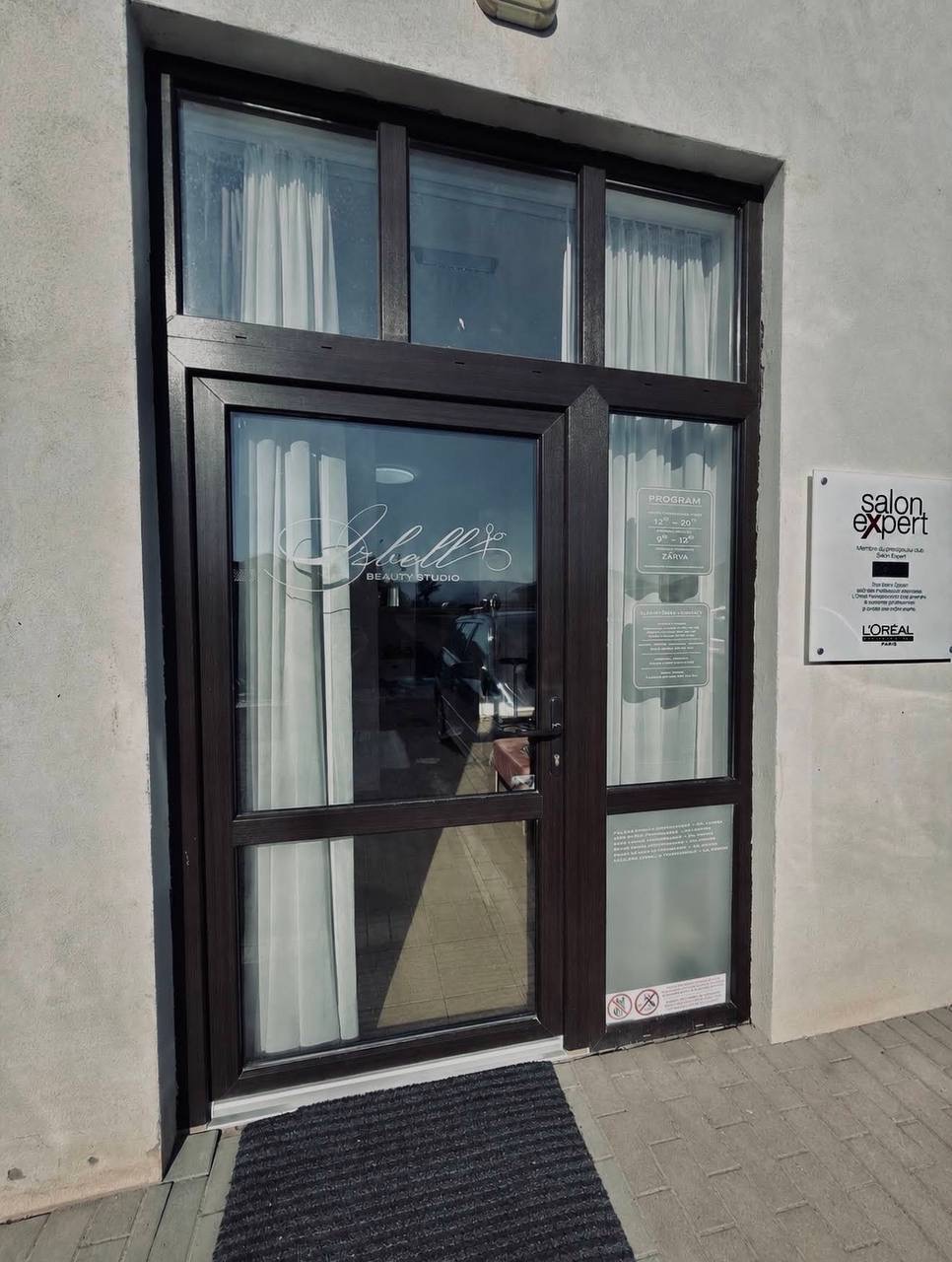 Az Izbell Beauty Studio bejárata, üvegajtó a L'Oréal Salon Expert táblával